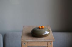 two oranges are placed on top of a small table in front of a couch