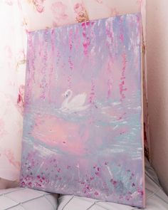 a white swan floating on top of a pink and blue watercolored painting in the corner of a room