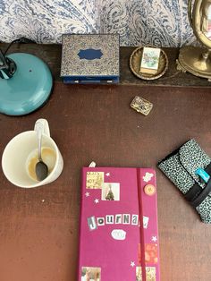 a table topped with notebooks and other items on top of a wooden table next to a mirror