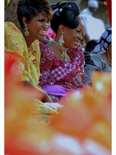 two women sitting next to each other smiling