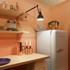 a small kitchen with pink walls and white refrigerator freezer next to wooden counter top