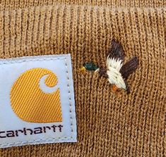 there is a small patch on the back of a sweater that has a duck in it