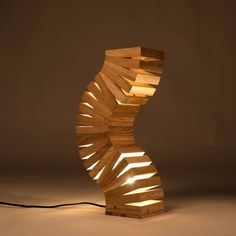 a lamp made out of wooden strips with light coming from the top and bottom, on a brown background