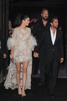 the couple are walking hand in hand