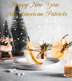 two glasses filled with liquid sitting on top of a white plate next to christmas trees