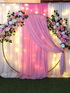 a decorated stage with pink drapes and flowers