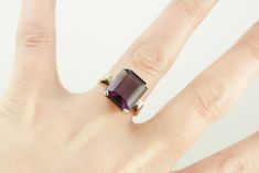 Classic elegance! We've completely restored this vintage, yellow gold mounting and set it with a gorgeous new amethyst of the deepest shade of aubergine purple! The bold but simple style of this ring allow it to be worn for a variety of occasions, from a day to day signature piece to an eye-catching accessory for the finest gown. Metal: 14K Yellow Gold Gem: Amethyst 9.55 Carats Gem Measurements: 13.9 x 11.9 mm, Rectangle Emerald Cut Ring Size: 7.25 Marks: "JAM14K" Stamped on the inside band Classic Emerald Cut Purple Rings, Classic Purple Emerald Cut Rings, Classic Emerald-cut Amethyst Ring, Classic Emerald Cut Amethyst Ring, Classic Purple Amethyst Ring, Classic Emerald Cut Solitaire Amethyst Ring, Purple Ruby Ring For Formal Occasions, Classic 14k Gold Purple Amethyst Ring, Vintage Purple Amethyst Ring With Polished Finish