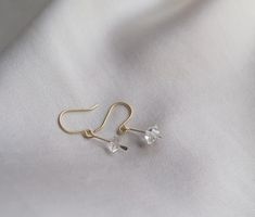 These dainty earrings are a cute way to add a little subtle sparkle to your look! Elegant and understated crystal earrings, but with a raw feel to them. The clean design of these earrings makes them really classy and versatile. Each earring contains a teeny floating Herkimer diamond. Herkimer diamonds are mined from a specific mine from New York State and are known by the double termination (pointy on both sides of the crystal) They are held in a little drop of brass, hammered for a rough textur Minimalist Dangle Crystal Earrings With Ear Wire, Minimalist Sterling Silver Crystal Earrings, Dainty Hypoallergenic Crystal Earrings For Everyday, Delicate Earrings With Simple Design For Gift, Delicate Simple Design Earrings For Gift, Minimalist Hypoallergenic Clear Earrings, Minimalist Clear Hypoallergenic Earrings, Minimalist Nickel-free Dangle Crystal Earrings, Minimalist Crystal Drop Earrings With Ear Wire