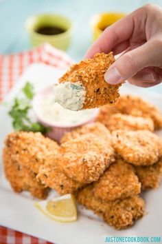 a person dipping sauce on some fried food