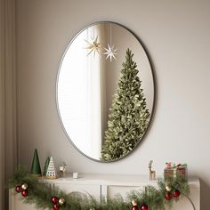 a christmas tree is hanging in front of a mirror on the wall next to a fireplace