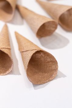 several cones made out of burlap on a white surface with one cone cut in half