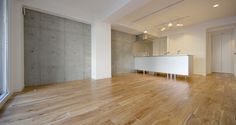 an empty room with hard wood floors and white cabinets