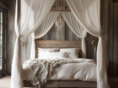 a bed with white drapes on top of it and a chandelier hanging from the ceiling