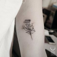 a woman's arm with a flower tattoo on the left side of her arm