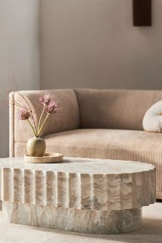 a marble coffee table with a vase on top