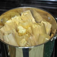 corn on the cob being cooked in a pot