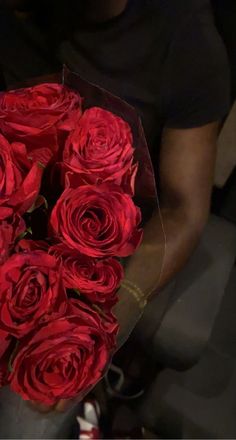 a man holding a bouquet of red roses