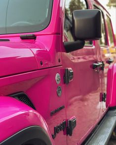 the pink jeep is parked on the side of the road