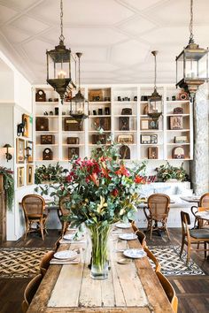 a dining room table with flowers in a vase