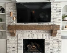 a white brick fireplace with a flat screen tv mounted above it's mantel