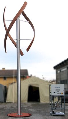 a large metal pole with a long ribbon on it's end next to a building