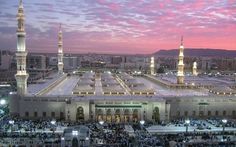 an aerial view of the grand mosque and surrounding buildings at dusk with pink clouds in the sky