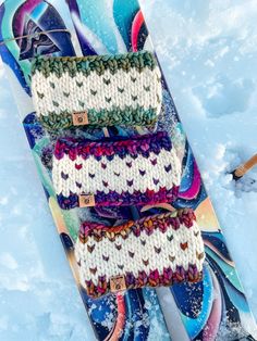 three knitted skis laying in the snow next to each other on top of some snow