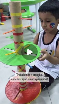 a little boy sitting on the floor with some toys