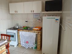 a small kitchen with a refrigerator, sink and stove top oven next to a table