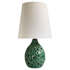 a green ceramic lamp with a white shade