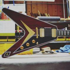 a guitar sitting on top of a table next to a pair of scissors and other items