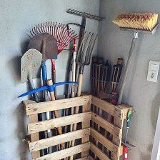 a wooden crate filled with gardening tools on top of a floor next to a wall