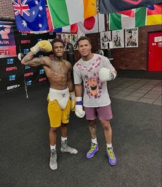 two men standing next to each other with boxing gloves on their hands and one holding a punching glove