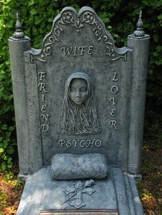 a black and white photo of a grave with a woman's head on it