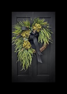 a wreath with pine cones and greenery is hanging on the front door to welcome guests