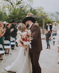 a bride and groom kissing in front of an outdoor ceremony