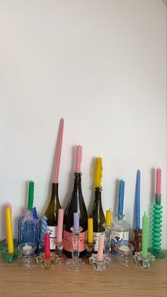 there are many different colored toothbrushes on the shelf next to wine bottles and candles