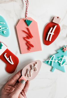 someone is holding an ornament in front of some christmas ornaments on a table