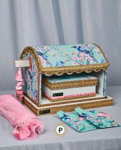 an elaborately decorated jewelry box sits on a table next to some pink gloves and other accessories