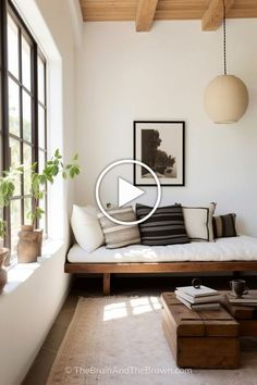 a living room filled with furniture and windows next to a wall mounted art piece on the wall