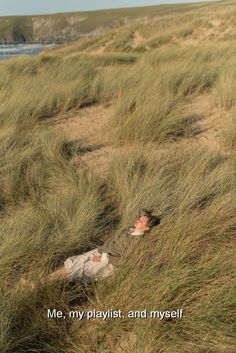 a man laying on the ground in tall grass