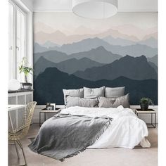 a bedroom with mountains painted on the wall and a large bed in front of it