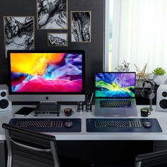 two computer monitors sitting on top of a desk next to a keyboard and monitor screen