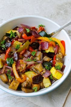 a white bowl filled with vegetables on top of a table