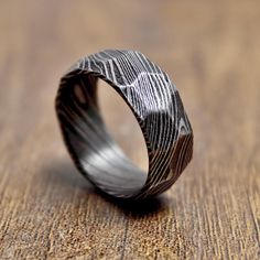 a ring that has been made to look like a finger print on it, sitting on a wooden surface