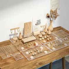 a wooden table topped with jewelry and vases on top of it's sides