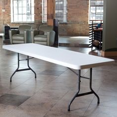 a white table sitting inside of a large room