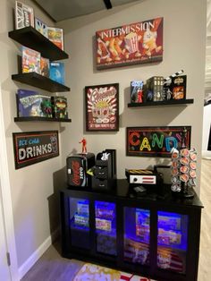 there are many signs on the wall in this room, including candy bars and soda machines