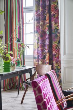 a living room filled with furniture and colorful curtains