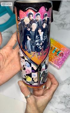 a person holding up a cup with pictures on it